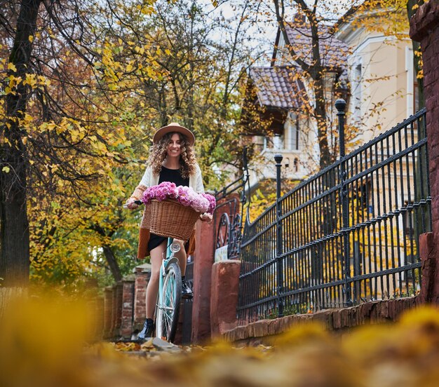 Hübsches Mädchen, das im Herbst auf der Stadtstraße radelt