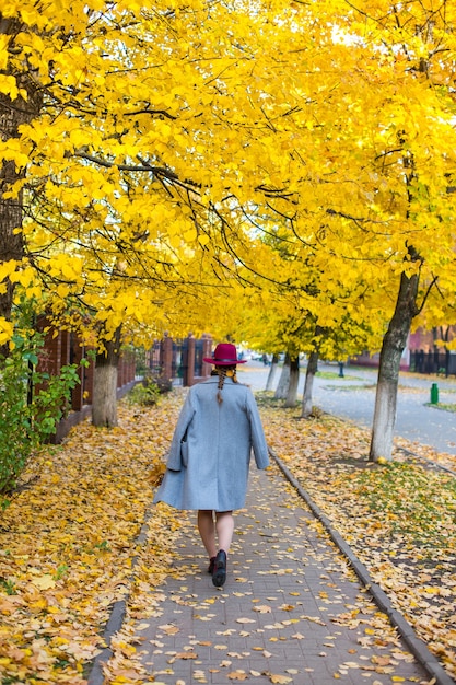 Hübsches Mädchen, das in die Herbststadt geht