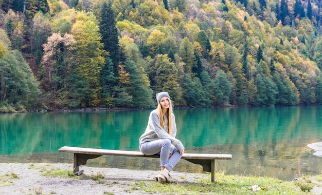 Hübsches Mädchen des Herbstes, das nahe Gebirgssee aufwirft. Herbstlandschaft im Wald.