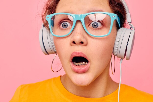 Hübsches Mädchen Grimasse Kopfhörer Musik Unterhaltungstechnologie isolierte Hintergründe unverändert