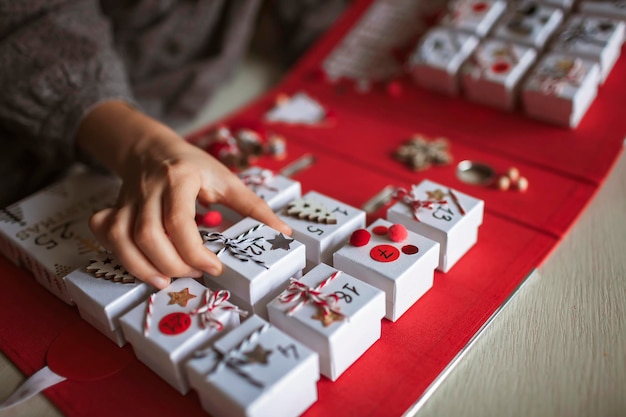 Hübsches Mädchen hält originellen Adventskalender aus Schmuckkästchen und Ordner Weihnachten DIY Handwerk