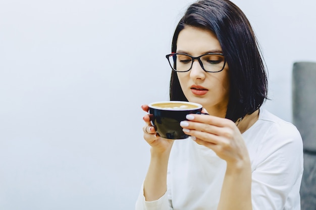 Hübsches Mädchen im Café trinkt Kaffee