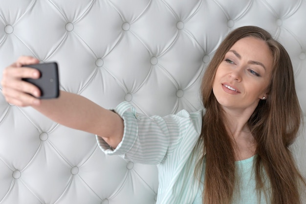 Hübsches Mädchen macht Selfie mit ihrem Smartphone