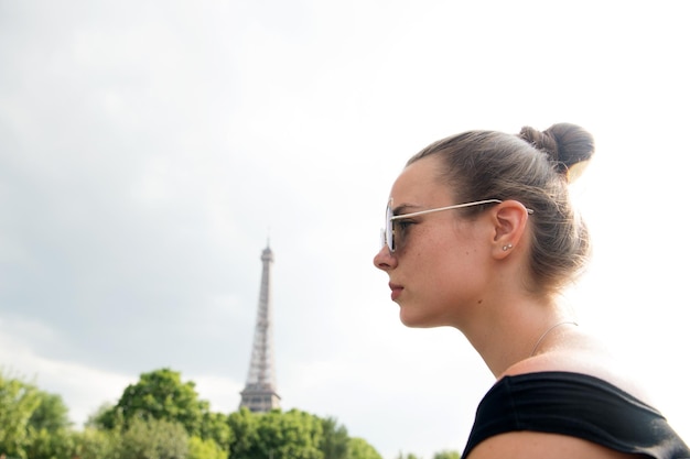 Hübsches Mädchen mit Blick auf den Eiffelturm in Paris, Frankreich. Schwarz und weiß. Romantisches Reisekonzept