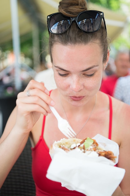 Hübsches Mädchen oder Frau, die Sandwich-Gyros essen. Mädchen isst gerne Burger nach der Diät. Sie öffnete den Mund, hielt einen Kreisel auf seinen ausgestreckten Händen und schloss die Augen.