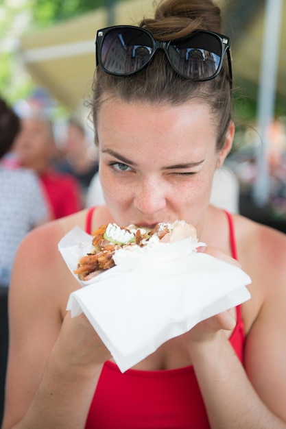 Hübsches Mädchen oder Frau, die Sandwich-Gyros isst Mädchen mit Vergnügen isst Burger nach der Diät Sie öffnete den Mund, hielt ein Gyros auf seinen ausgestreckten Händen und schloss die Augen