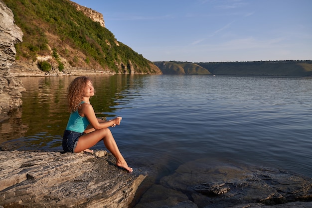 Hübsches Model sitzt am Ufer des Sees