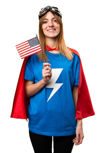 Hübsches Superheldenmädchen, das eine amerikanische Flagge hält