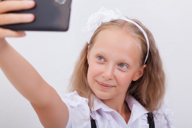 Hübsches Teenager-Mädchen macht Selfies mit ihrem Smartphone