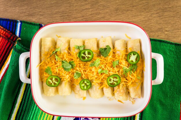 Hühnchen-Enchiladas mit Cheddar-Käse und Sauce.