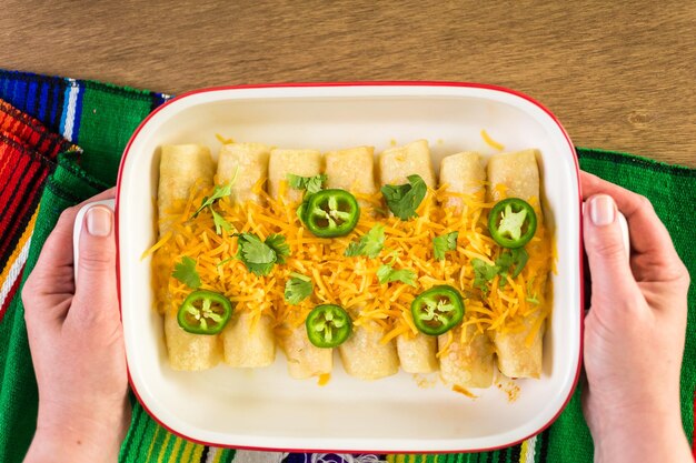 Hühnchen-Enchiladas mit Cheddar-Käse und Sauce.