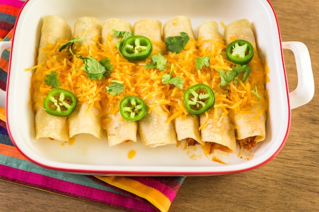 Hühnchen-Enchiladas mit Cheddar-Käse und Sauce.