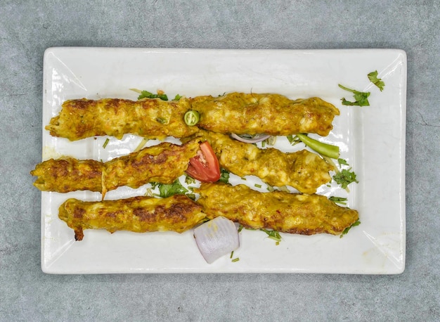 Hühnchen-Käse-Reshmi-Kabab, serviert in einer Schüssel, isoliert auf dem Hintergrund, Draufsicht auf indische Gewürze und pakistanisches Essen