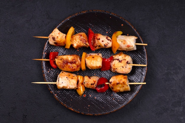 Hühnchen-Kebab mit gegrilltem Gemüse auf Holzspießen.