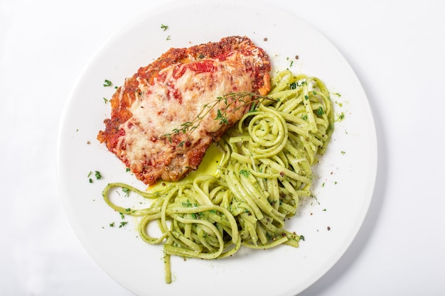 Hühnchen mit Parmesankäse und Linguine-Nudeln in Pesto-Sauce auf weißem Hintergrund