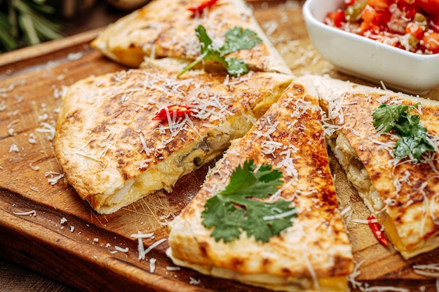 Hühnchen-Quesadilla mit Salsa-Sauce auf Servierbrett