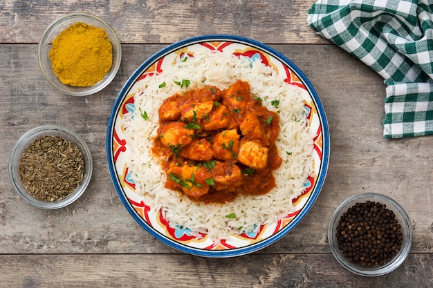 Hühnchen-Tikka-Masala mit Basmatireis auf Holztischoberansicht