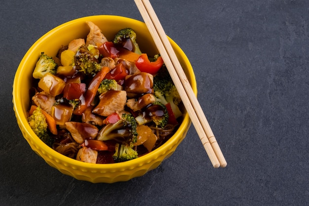 Hühnchen-Yakissoba in gelber Schüssel.