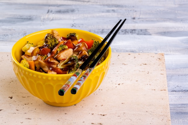 Hühnchen-Yakissoba in gelber Schüssel.