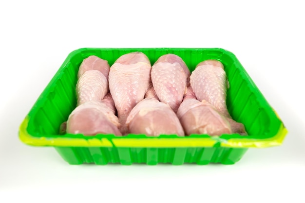Hühnerbein in einem Tablett, isoliert auf weißem Hintergrund, von oben gesehen