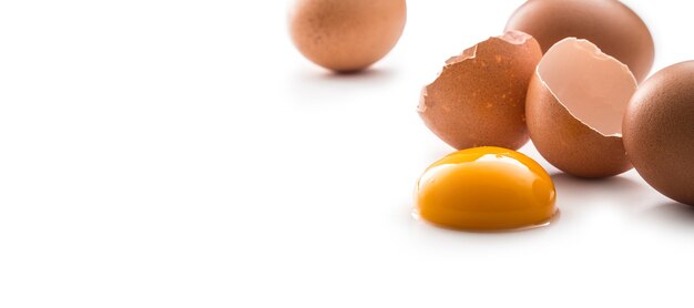 Hühnereier und gebrochenes Ei mit Eigelb isoliert auf weißem Hintergrund.