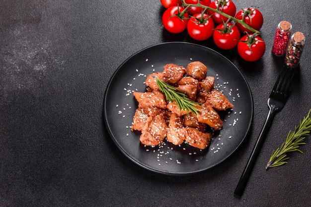 Hühnerfilet in Sesam, Teriyaki-Sauce auf einer schwarzen Steinplatte. asiatische Küche