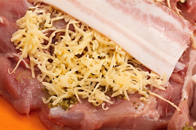 Hühnerfleisch mit geriebenem Käse, Speck und Gewürzen.