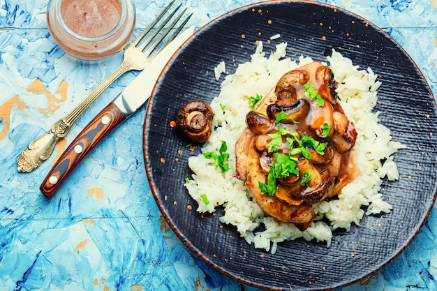 Hühnerfleisch mit Pilzsauce auf einem Reispad. Hähnchenbrust mit italienischer Marsala-Sauce.