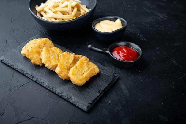 Hühnernuggets auf schwarzem Tisch gebraten.