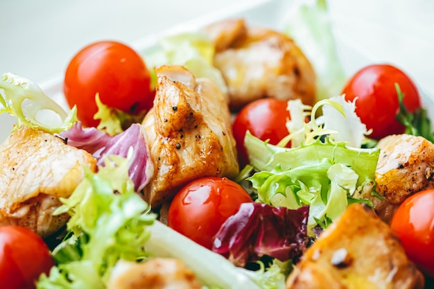 Hühnersalat mit Kirschtomaten, Salat und Gemüse für gesunde Ernährung, Lieferservice und Online-Bestellkonzept