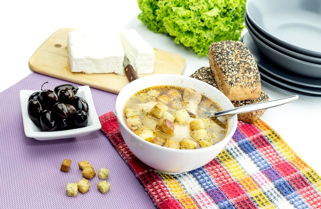 Hühnersuppe in einem weißen Teller auf einer Tischnahaufnahme