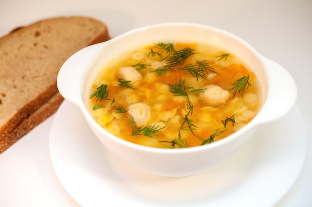 Hühnersuppe mit Fleischbällchen und Nudeln auf dem Tisch