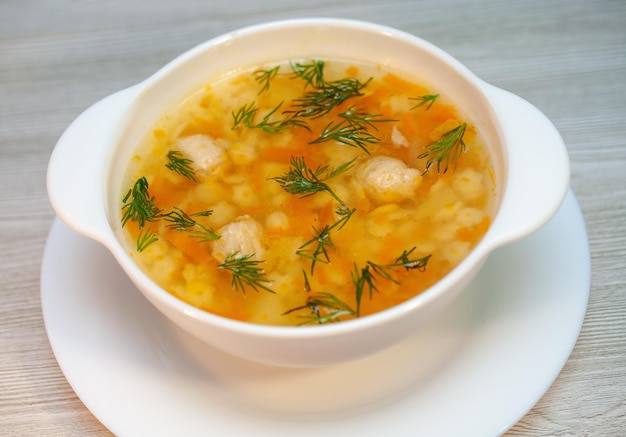 Hühnersuppe mit Fleischbällchen und Nudeln auf dem Tisch