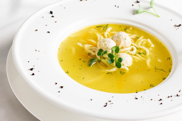 Hühnersuppe mit Fleischklöschen und Nudeln in der weißen Tabelle