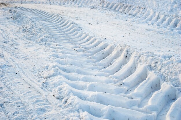 La huella de la pisada de las ruedas del tractor en la nieve.