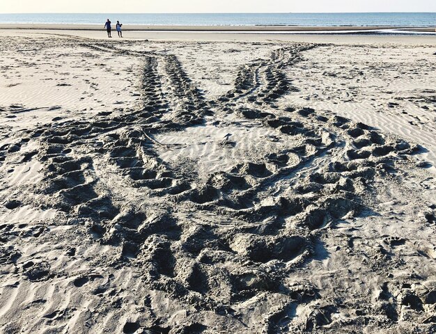 Foto huellas en la arena de la playa contra el cielo