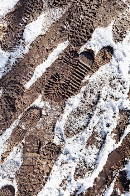 Huellas en camino sucio cubierto de nieve