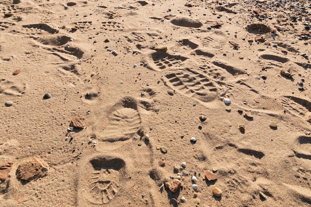 Huellas y huellas de botas en la arena