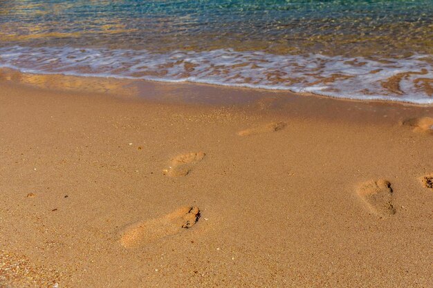 Huellas humanas en la playa de arena Concepto de vacaciones de verano