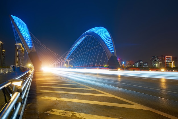 Huellas de luces y sombras de automóviles en puentes y carreteras por la noche