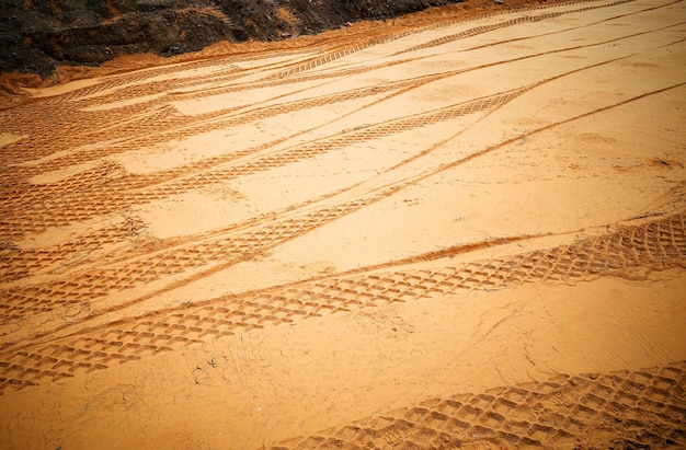 Huellas de neumáticos de coche en el fondo de la superficie de arena