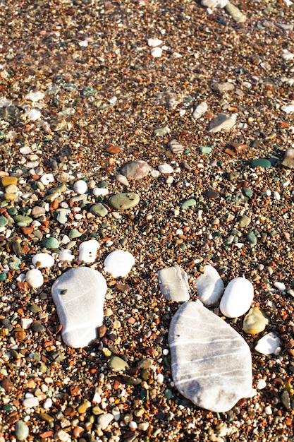 Huellas de piedra en la playa. Concepto de spa o vocación. Orilla del mar adriático