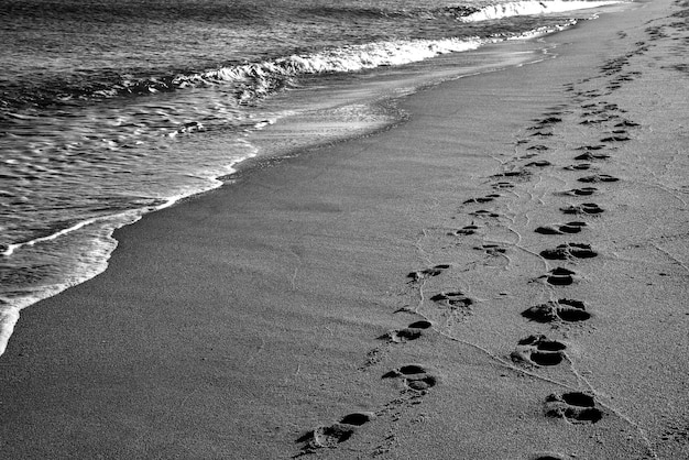 Huellas en la playa Una huella de pies humanos en la arena cerca del mar