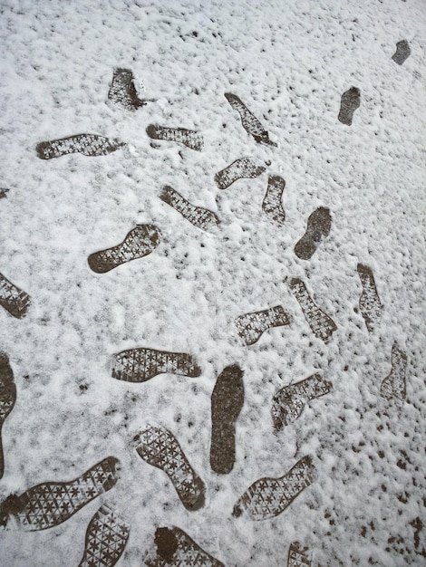 Foto huellas de zapatos en el campo cubierto de nieve