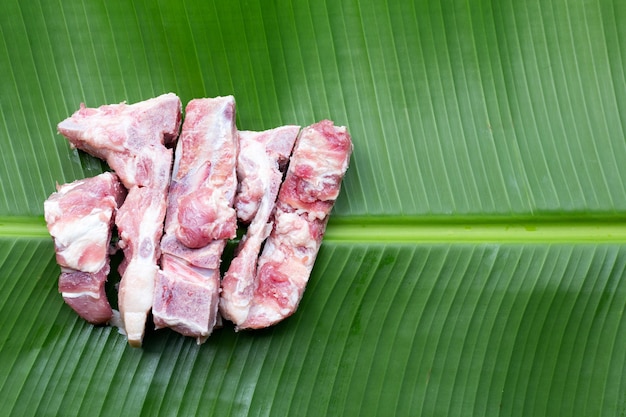 Hueso de cerdo crudo en hoja de plátano