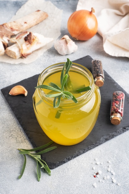 Hueso de res y caldo de verduras con condimento de cúrcuma en un frasco de vidrio