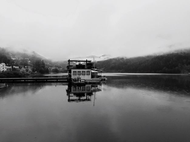 Foto hütte-reflexion im see bei baselga di pine gegen bewölkten himmel