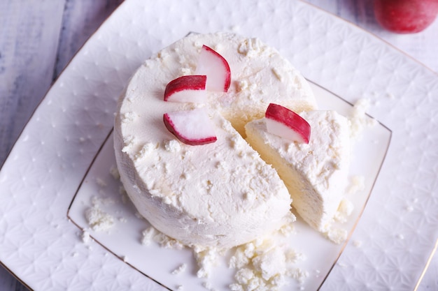 Foto hüttenkäse auf teller und rettich auf holzhintergrund