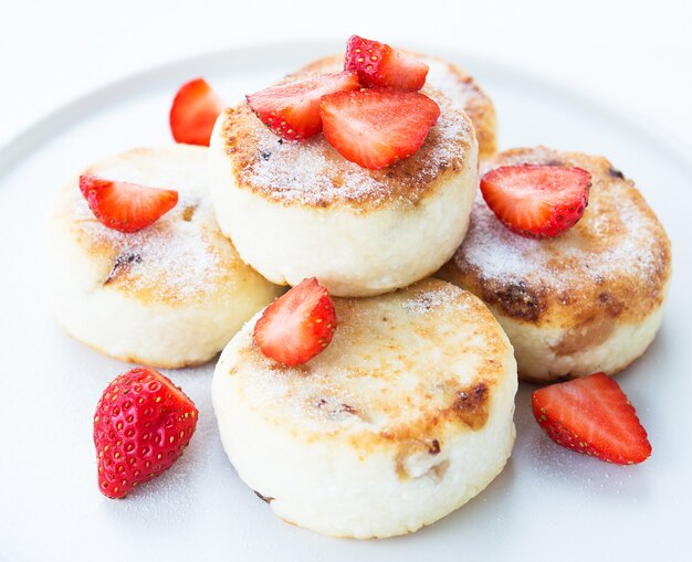 Hüttenkäse-Käsekuchen mit Erdbeeren und Puderzucker, Nahaufnahme