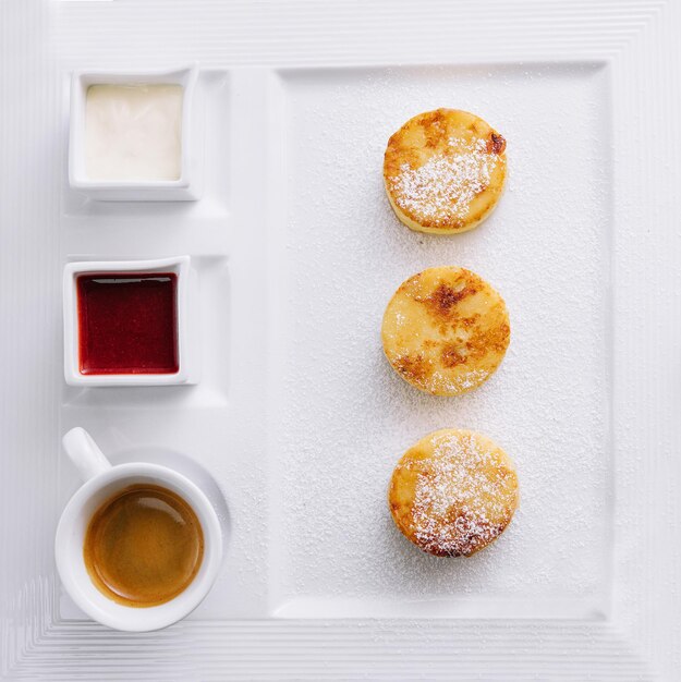 Hüttenkäse-Pfannkuchen mit Beerensauce und Sauerrahm und Kaffee